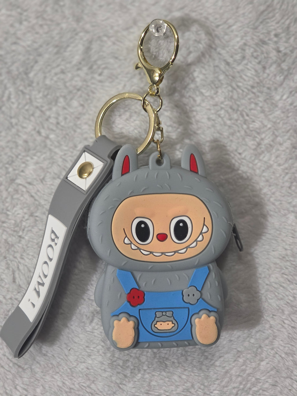 Labubu-inspired gray monster bunny mini pouch keychain back view showing gray textured silicone body with wristlet strap and gold hardware