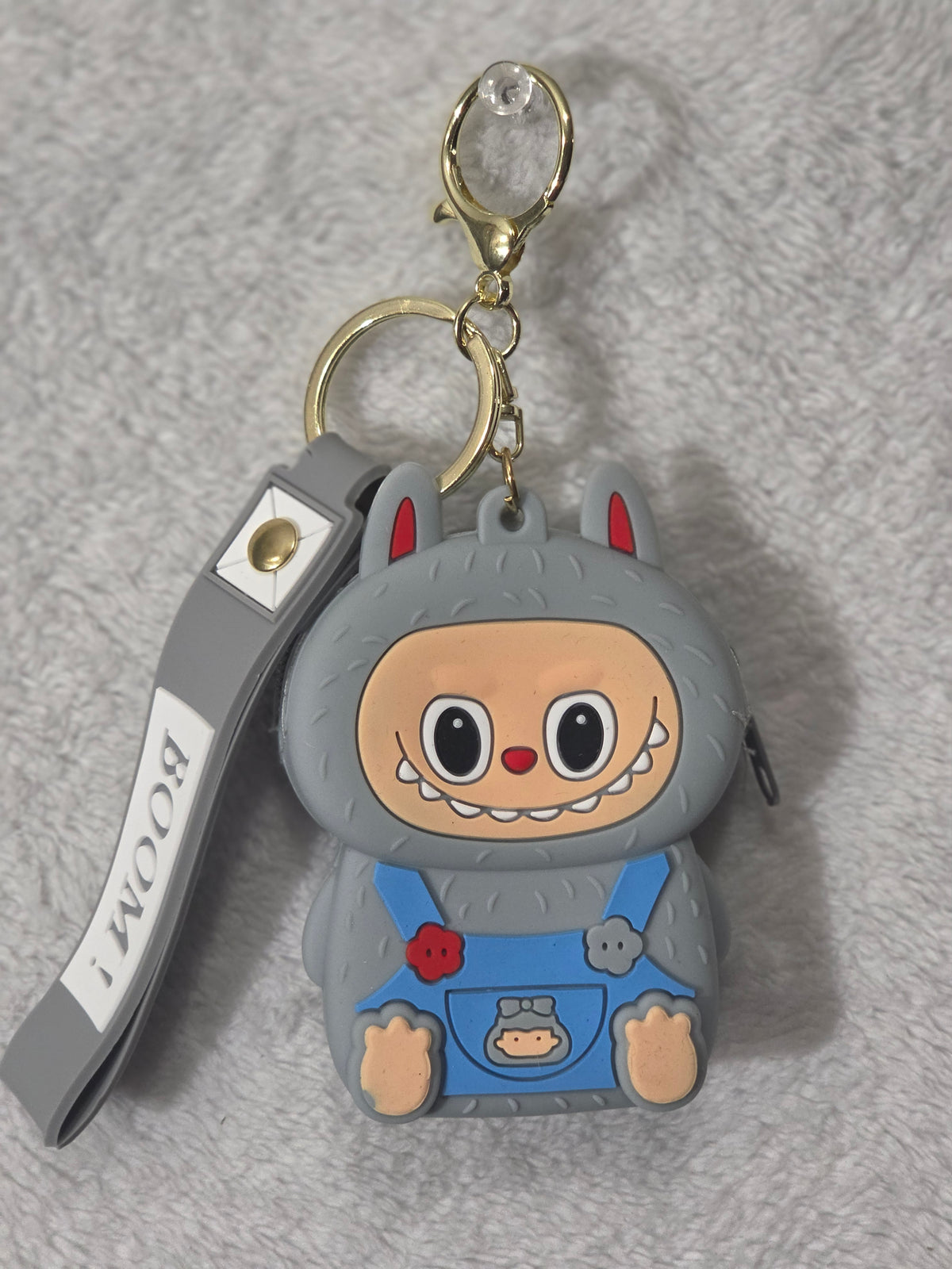 Labubu-inspired gray monster bunny mini pouch keychain back view showing gray textured silicone body with wristlet strap and gold hardware