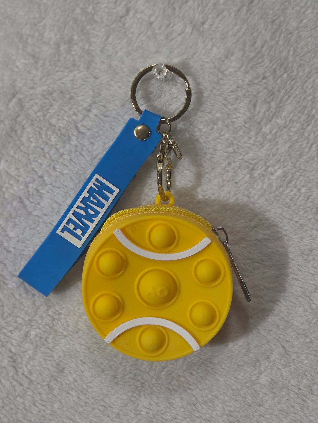 Marvel pop-it yellow silicone round mini pouch keychain front view showing bubble grid with white stripe accents and blue Marvel wristlet strap