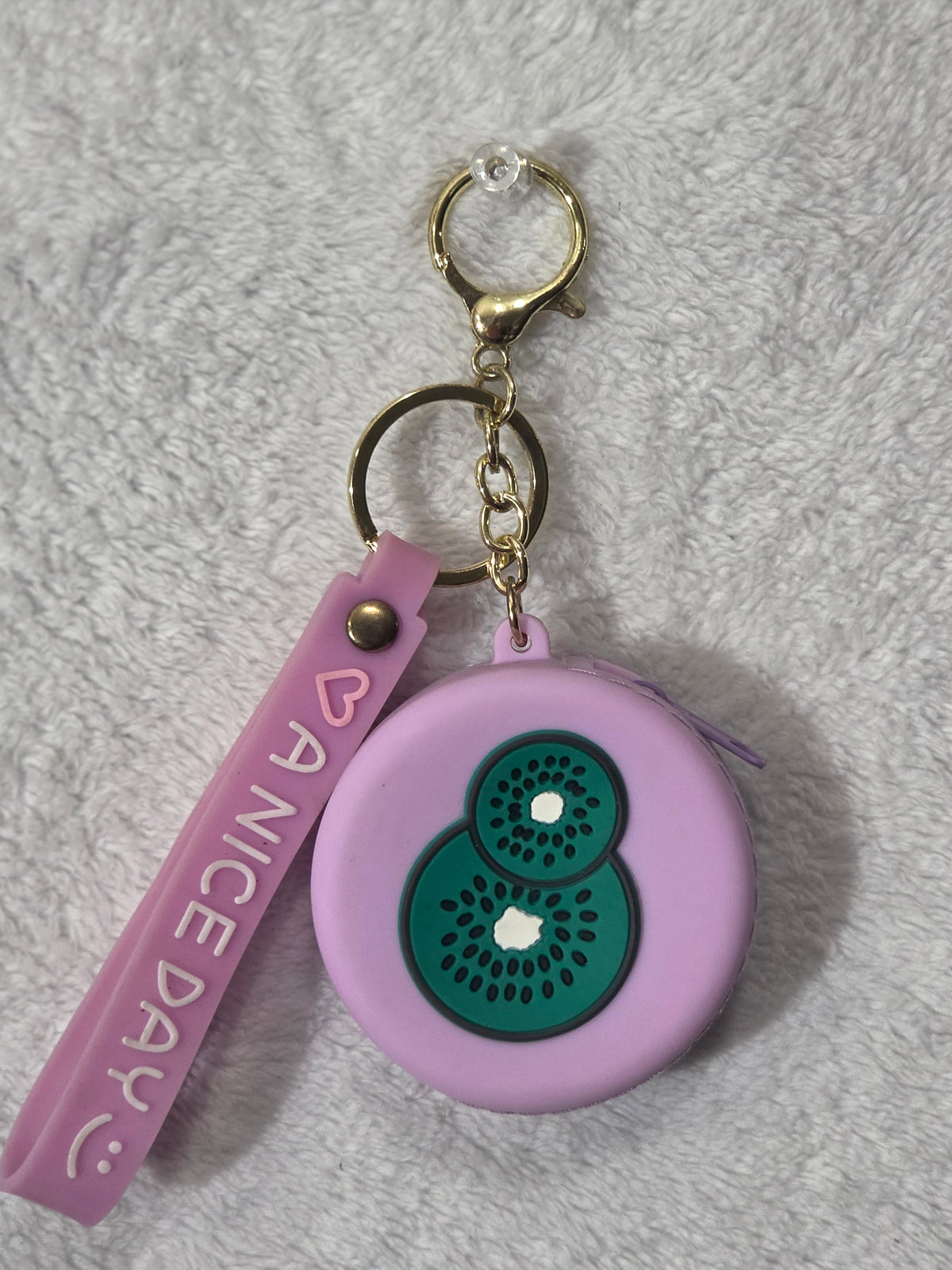 Kiwi fruit lavender silicone round mini pouch keychain front view showing two overlapping kiwi slice design with lavender A Nice Day wristlet strap
