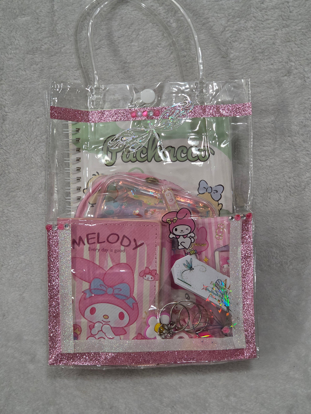My Melody Happy Day bag — sealed and packed showing AEFF thank you card and Pachacco notebook through clear bag