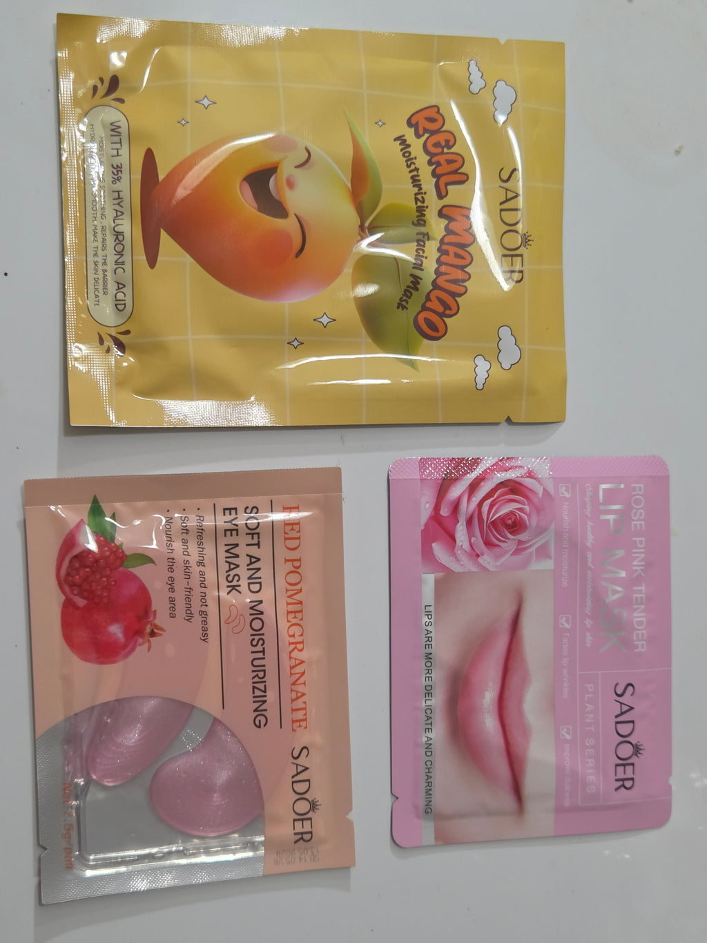 Mango facial mask, rose lip mask, and red pomegranate eye mask included in the bag